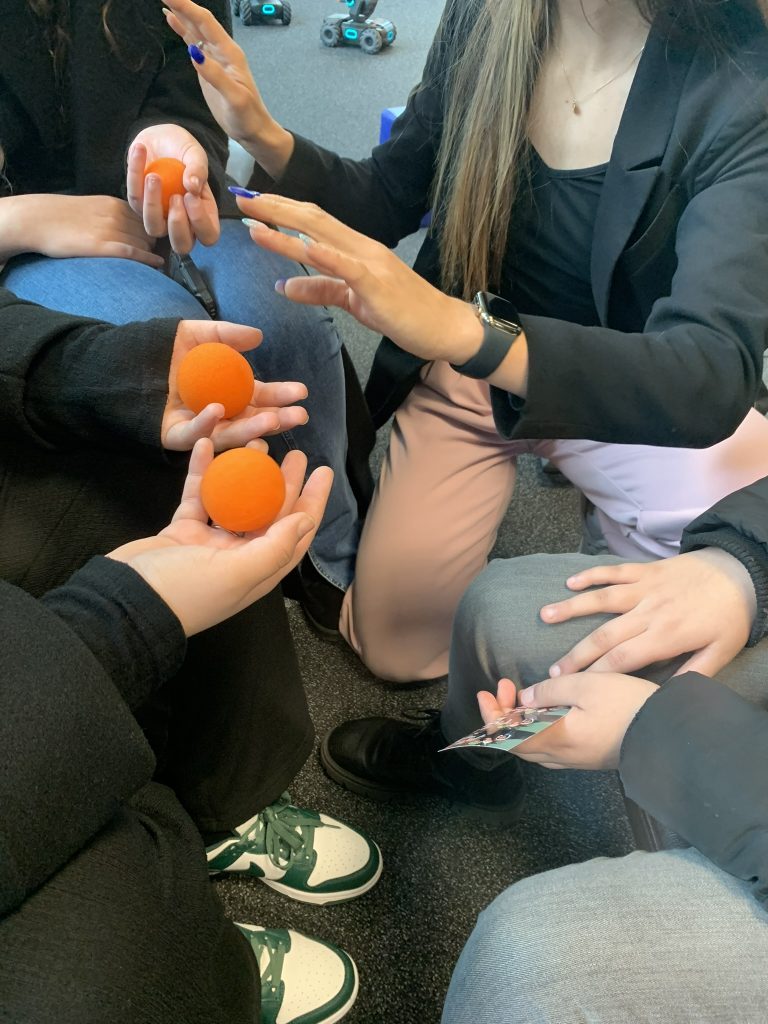 Magicienne réalisant un tour de close-up interactif avec des balles en mousse dans les mains des spectateurs