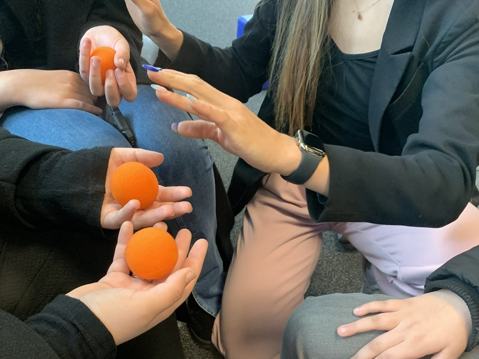 Magicienne réalisant un tour de close-up interactif avec des balles en mousse dans les mains des spectateurs