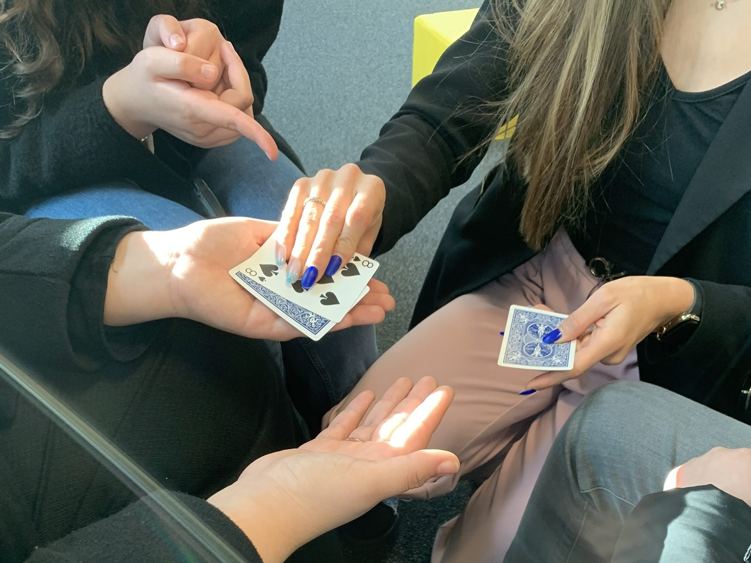Magicienne réalisant un tour de bonneteau avec trois cartes sur une table